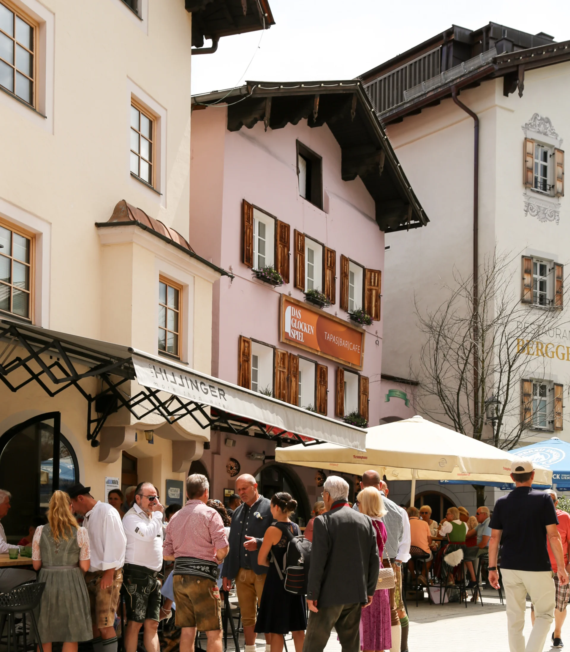 Schlosshotel – 5 Sterne in Kitzbühel Menschen in Trachten bei einer Straßencafé-Szene in einer europäischen Stadt