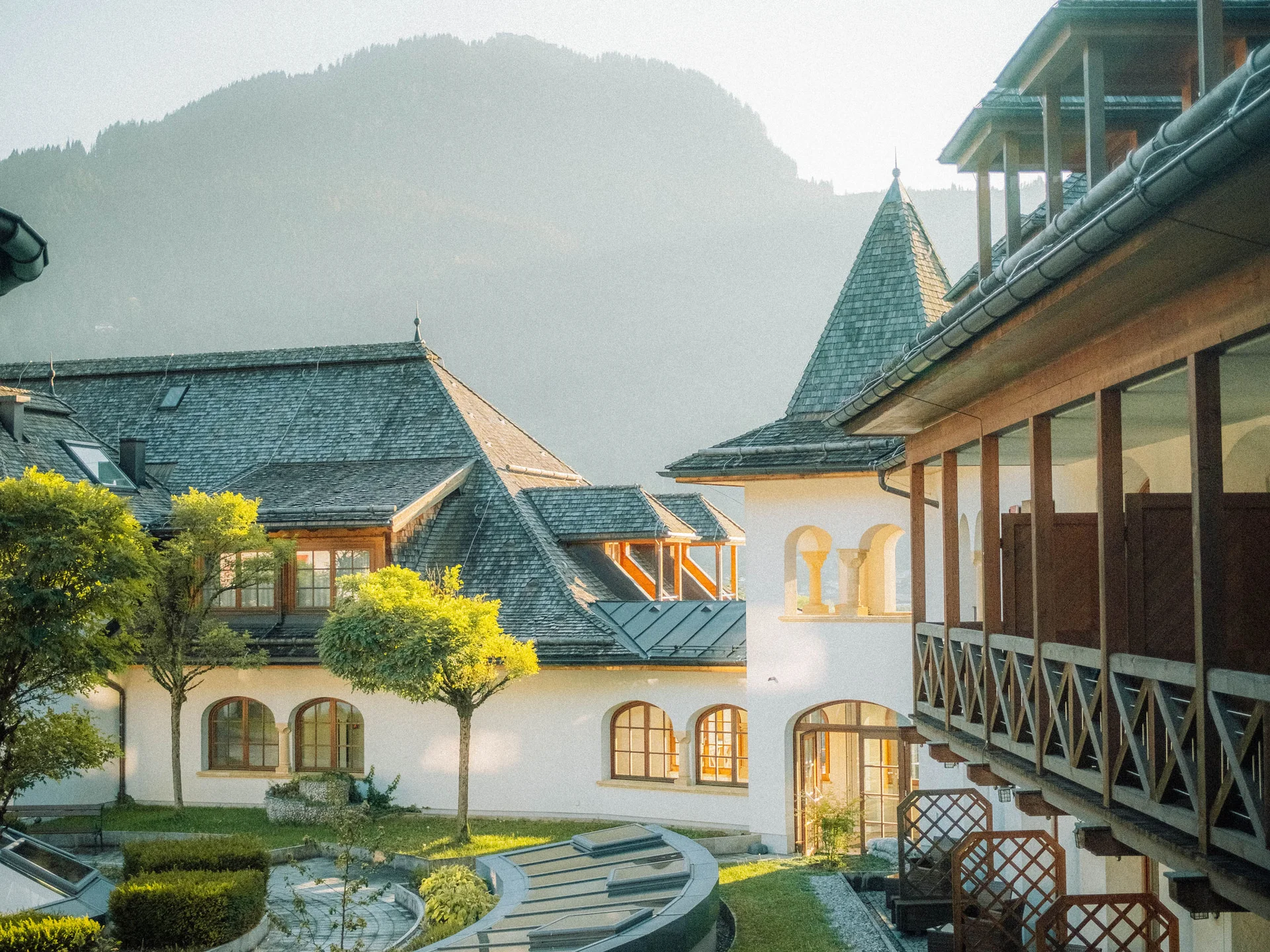 Bilder, die Sie sehen müssen. Historisches Gebäude mit Garten und Bergen im Hintergrund bei Sonnenlicht