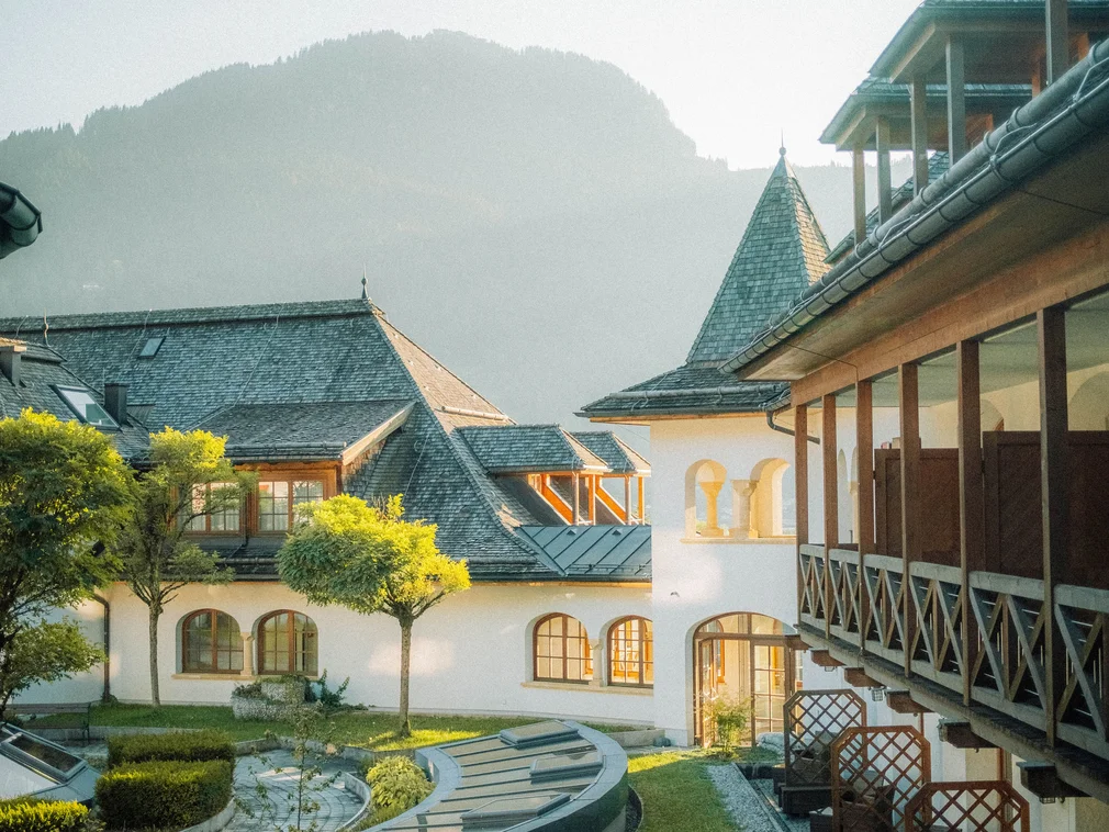 Bilder, die Sie sehen müssen. Historisches Gebäude mit Garten und Bergen im Hintergrund bei Sonnenlicht