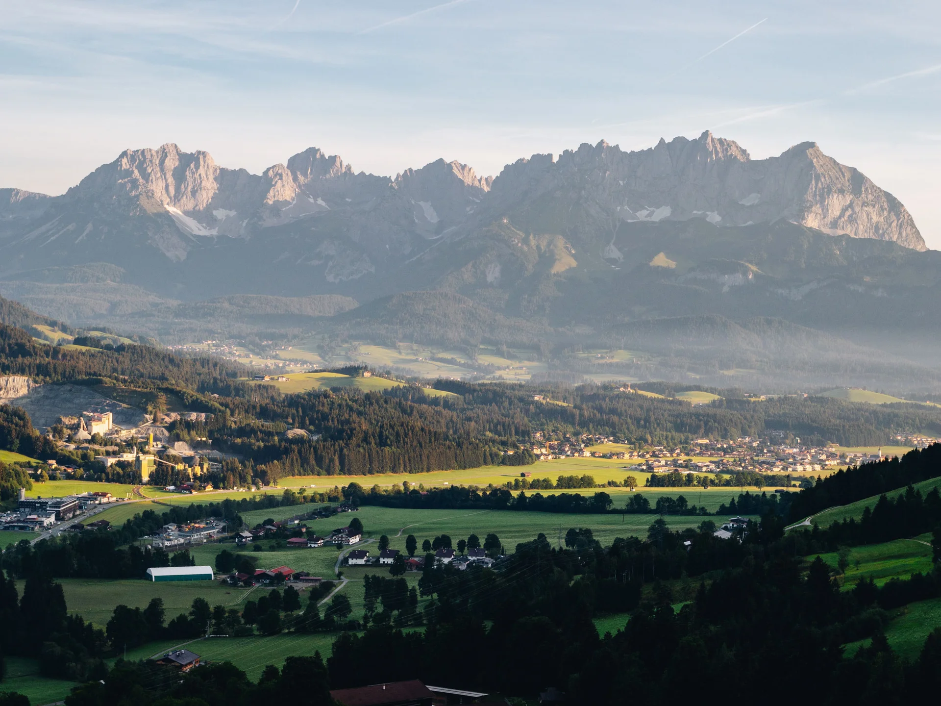 Bilder, die Sie sehen müssen. Berglandschaft mit grünen Wiesen und einem Tal bei klarem Himmel