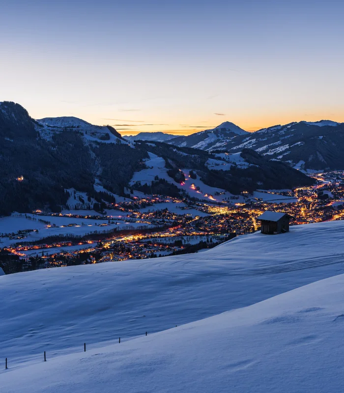 Ausflugsziele & Sehenswürdigkeiten rund um Kitzbühel Blick auf verschneite Berge und ein beleuchtetes Tal bei Sonnenuntergang