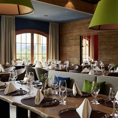 Eine der schönsten Hochzeitslocations in Tirol Elegantes Restaurant mit gedeckten Tischen und großen Fenstern