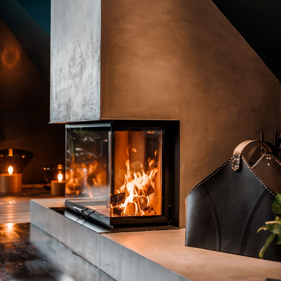 Eine der schönsten Hochzeitslocations in Tirol Moderner Kamin mit brennendem Feuer in gemütlichem Wohnzimmer