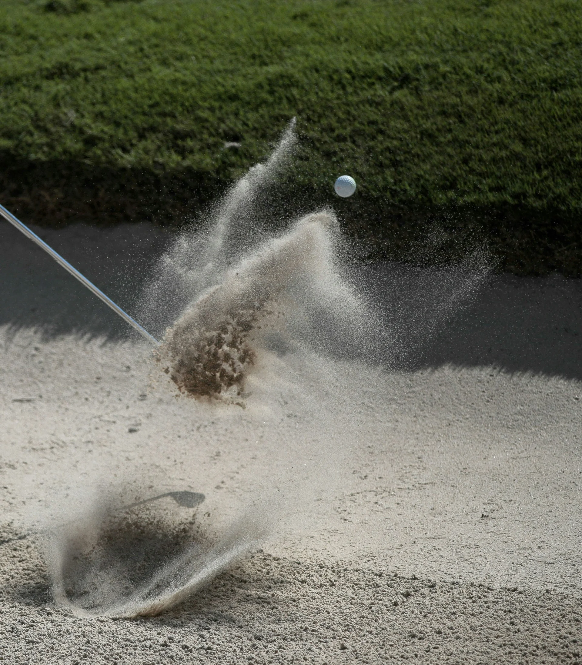 Das Golfhotel in Kitzbühel Golfball fliegt aus dem Bunker, Sand spritzt beim Schlag in einem Golfplatz