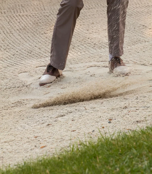 Das Golfhotel in Kitzbühel Golfspieler schlägt Ball aus dem Sandbunker