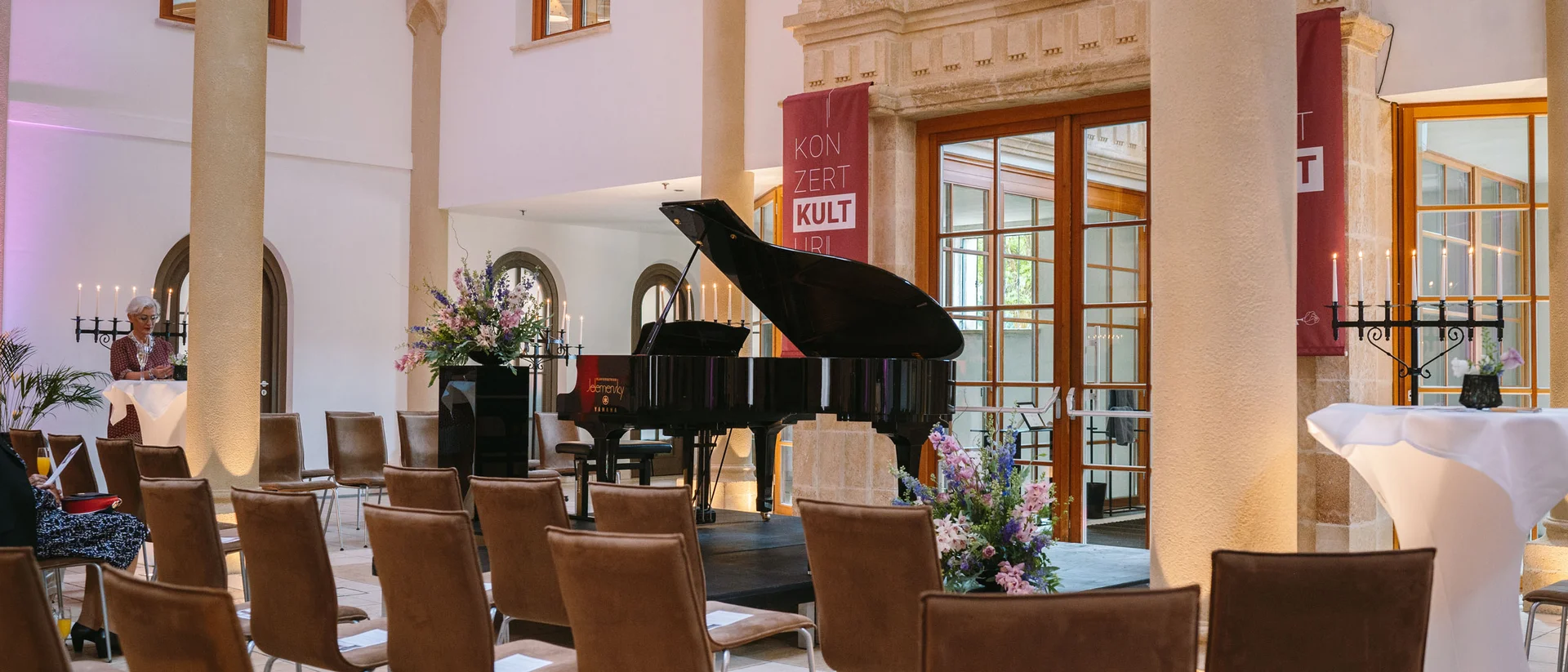 Die Schlossevents Leeres Konzertsaal mit Flügel und Stühlen in elegantem Raum mit Bögen