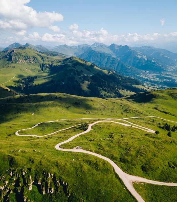 Ausflugsziele & Sehenswürdigkeiten rund um Kitzbühel Wunderschöne grüne Berglandschaft mit gewundenen Straßen unter blauem Himmel