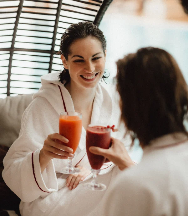 Schlosshotel Day Spa Zwei Frauen im Bademantel stoßen mit frischen Säften an