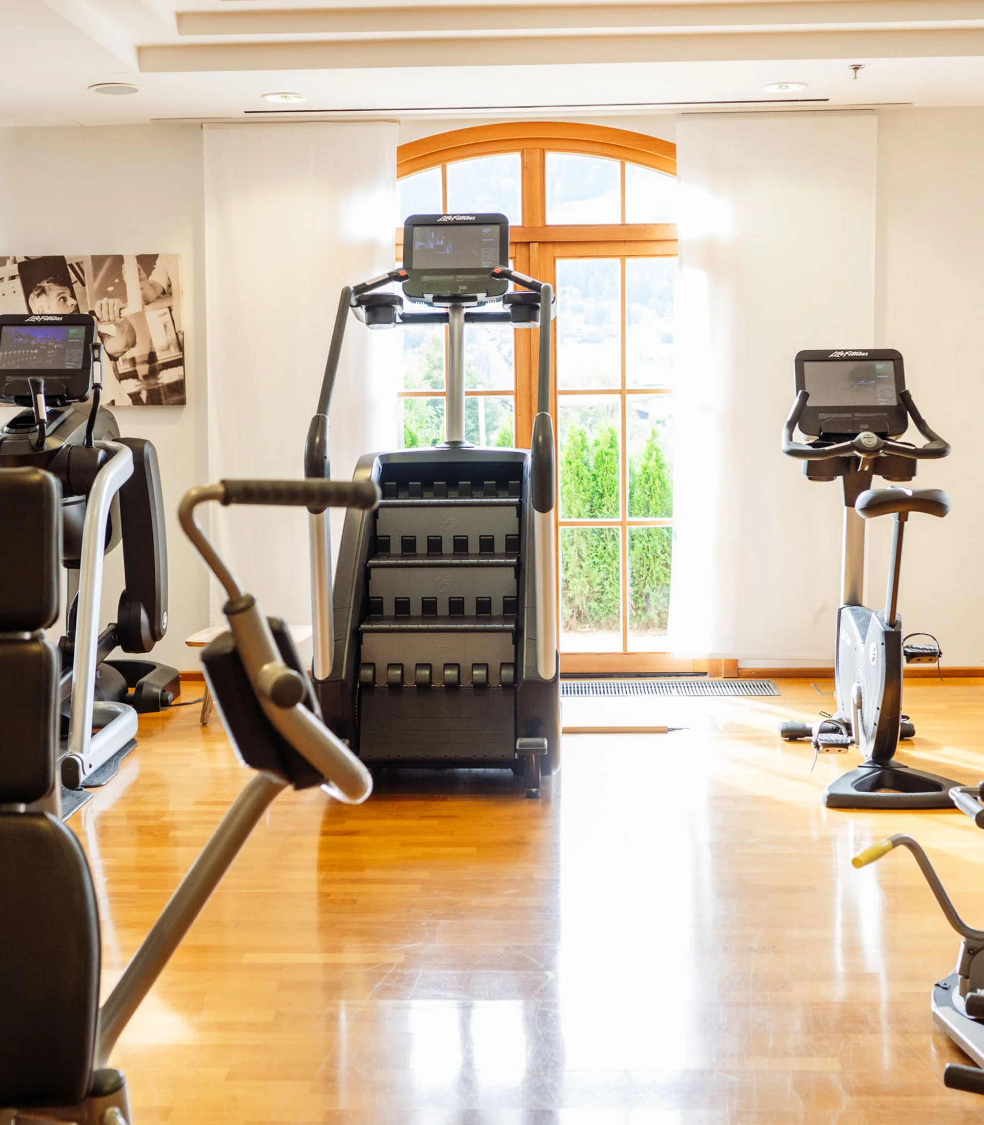 Fitness und Yoga im Hotel in Tirol Helle Fitnessstudio mit verschiedenen Trainingsgeräten und Holzboden