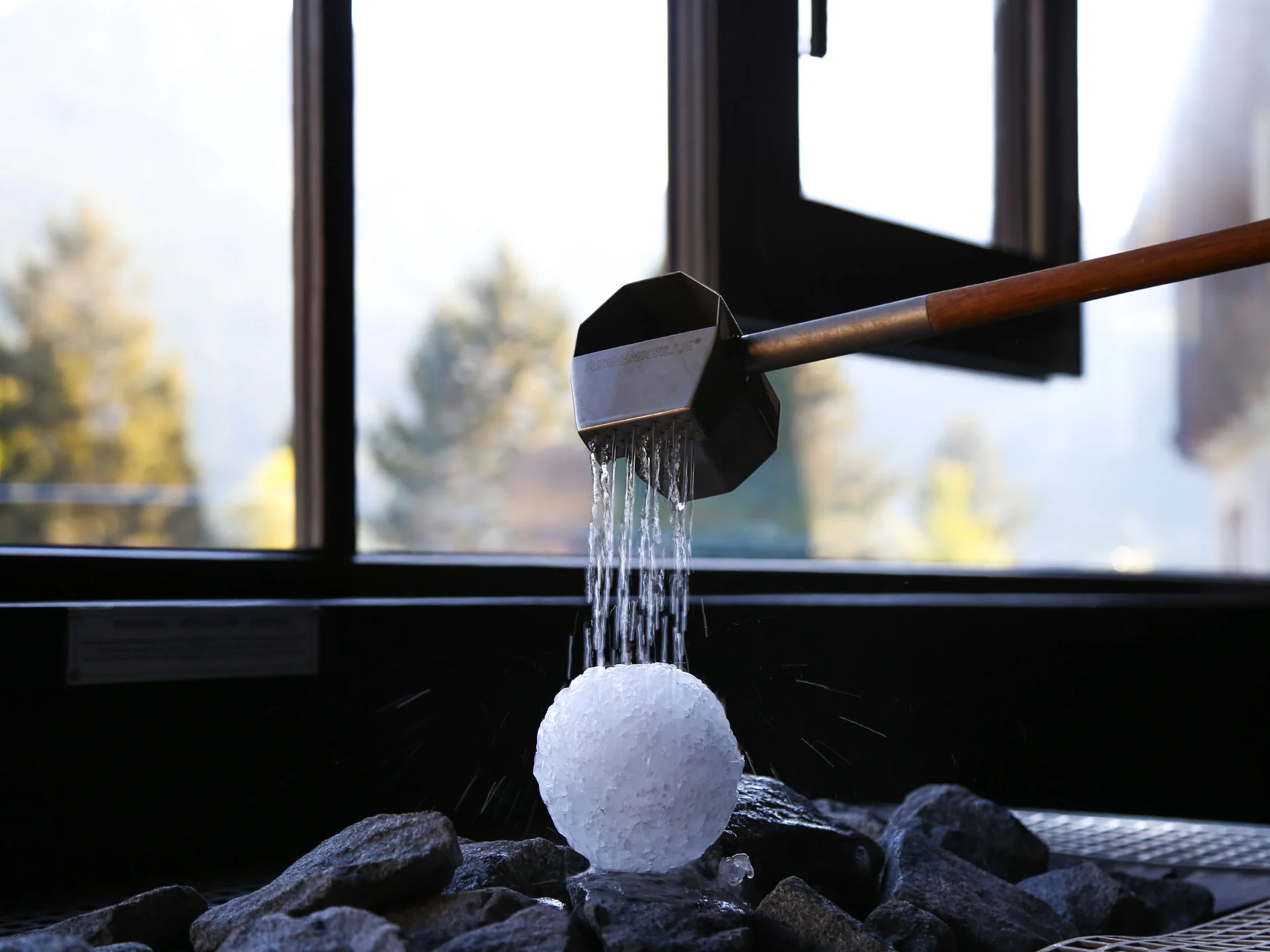 Bilder, die Sie sehen müssen. Wasser läuft aus einem Sieb auf einen Eisklumpen in einem Raum mit Fenster