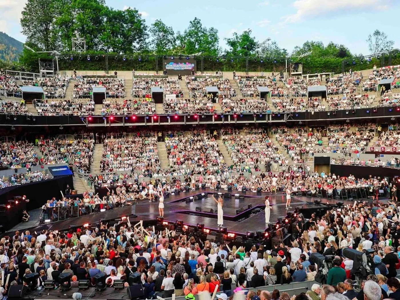 Die Schlossevents Volles Amphitheater mit Zuschauern bei einer Modenschau im Freien