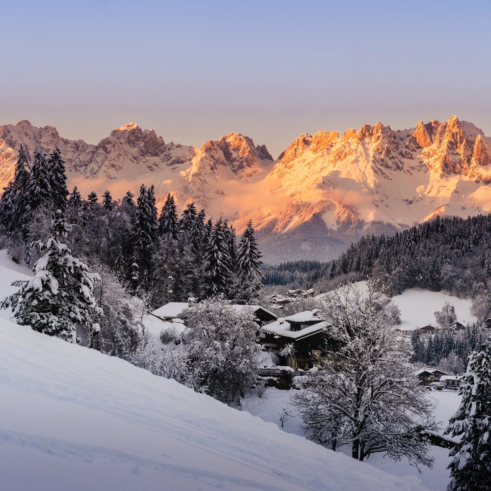 Schlosshotel – 5 Sterne in Kitzbühel Schneebedeckte Berge und Häuser im Winter bei Sonnenuntergang