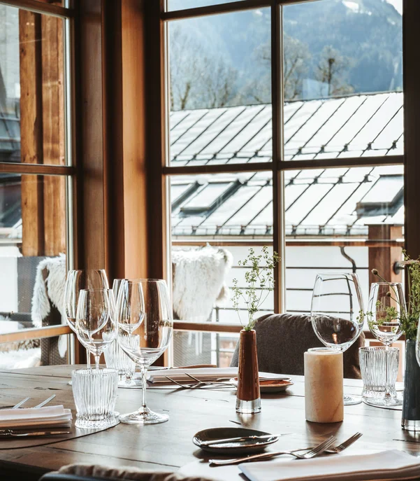 Silvester in Kitzbühel = Hotel, Party, Champagner Eleganter gedeckter Tisch in einem Restaurant mit Bergblick