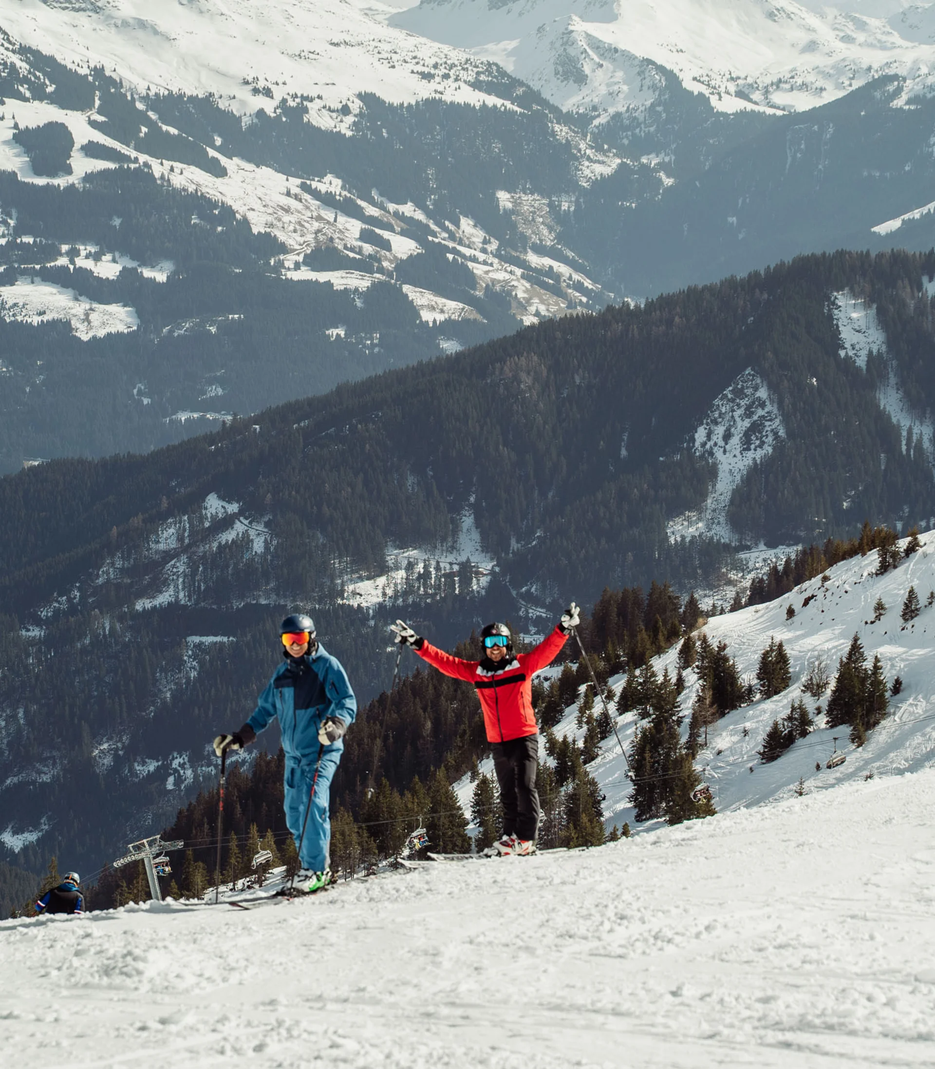 Ultimatives Skihotel in Kitzbühel Zwei Skifahrer auf verschneiter Bergpiste vor alpiner Landschaft