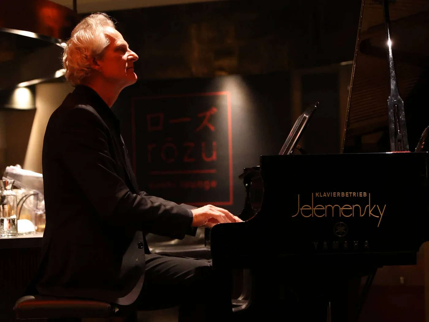 Die Schlossevents Mann spielt Klavier in dunklem Raum mit Hund darunter