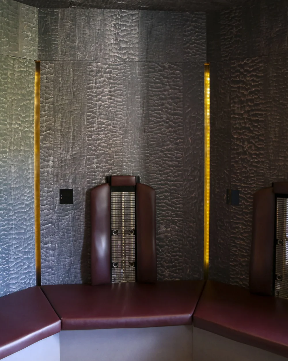 In Kitzbühel ein Hotel mit Pool, bitte. Moderne Sauna mit braunen Ledersitzen und strukturierter grauer Wand