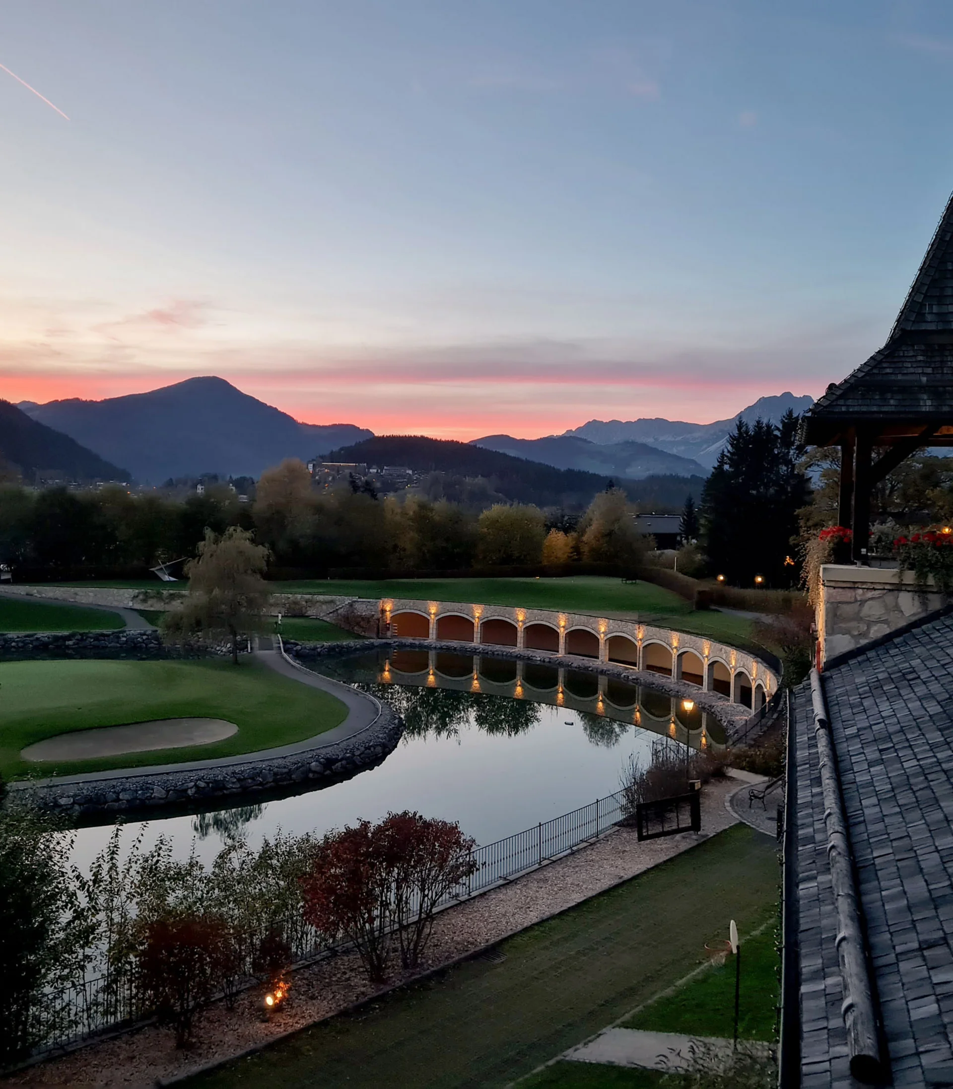 Hotel mit Klavier und Livemusik | Die Bar im Schlosshotel Kitzbühel Blick auf eine Golflandschaft und Berge bei Sonnenuntergang