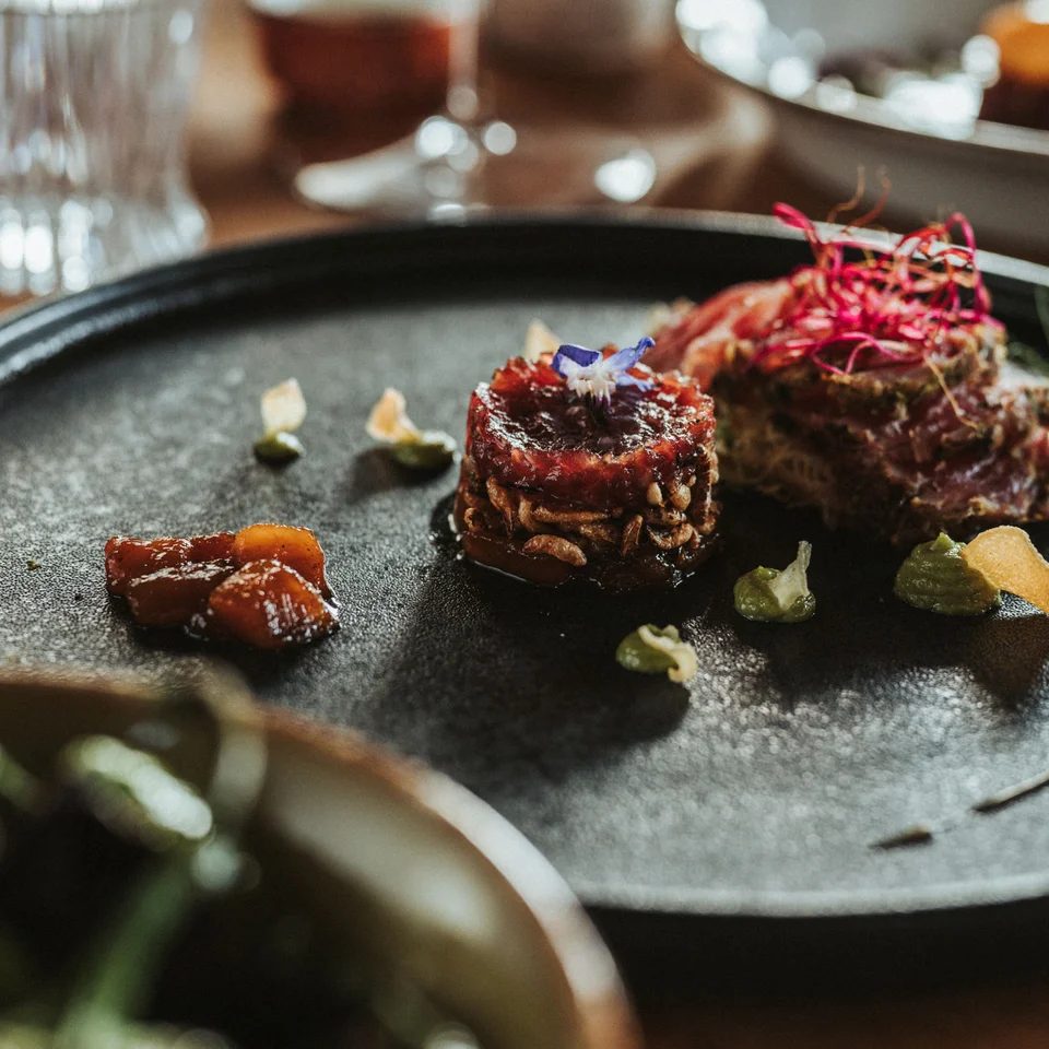 Eine der schönsten Hochzeitslocations in Tirol Fein angerichtete Gourmetvorspeise auf schwarzem Teller