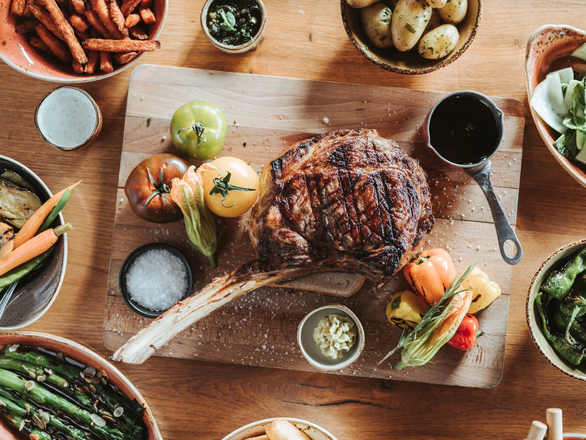 Bilder, die Sie sehen müssen. Gegrilltes Steak mit Gemüse und Beilagen auf einem Holzbrett