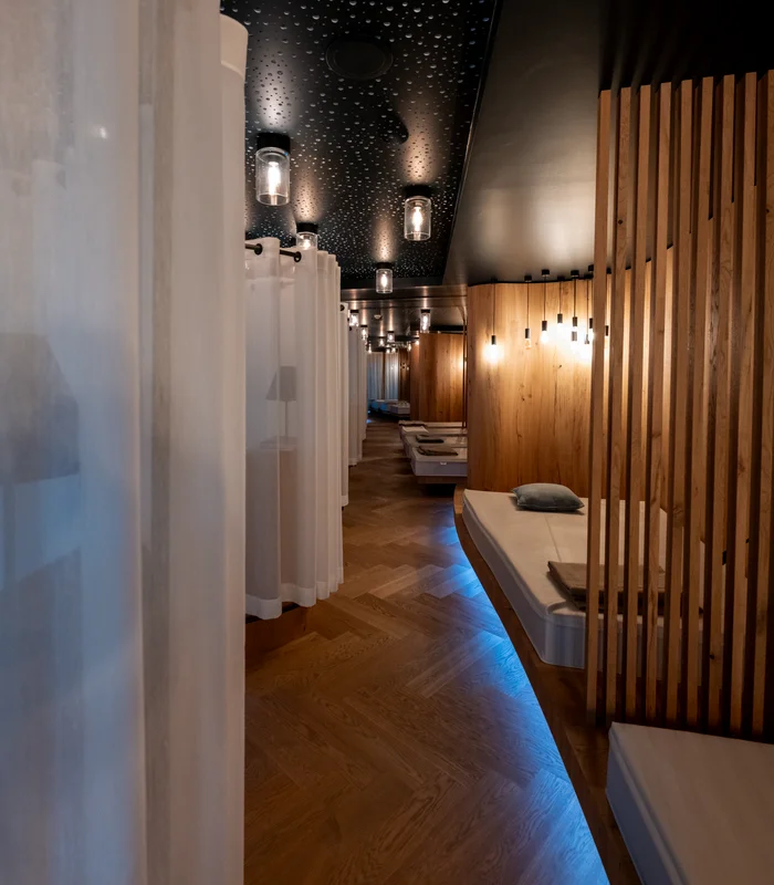 Premium-Spa im Wellnesshotel in Kitzbühel Innenansicht eines modern beleuchteten Ruheraums mit Liegen und Vorhängen