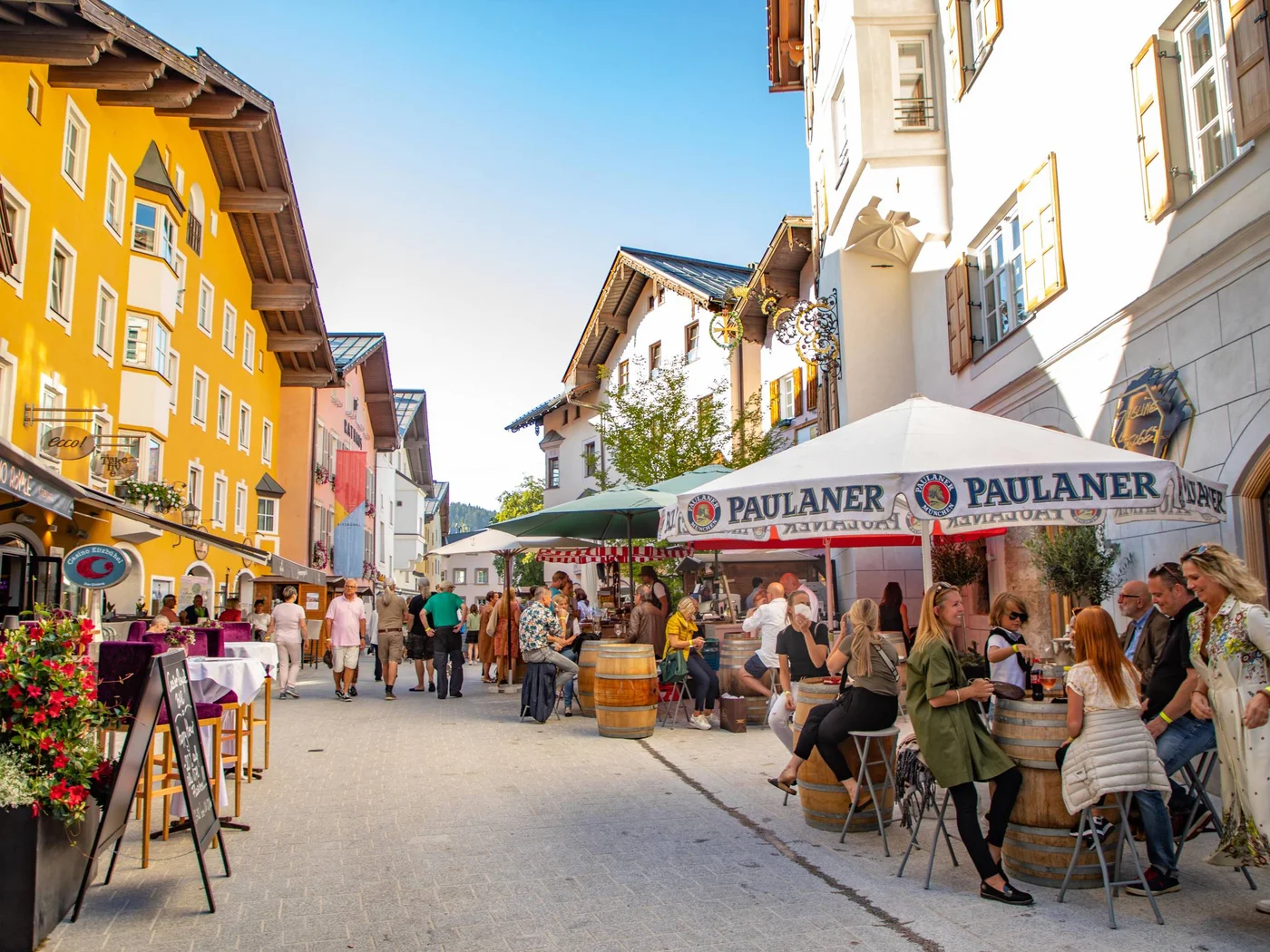 Die Schlossevents Belebte Fußgängerzone mit Cafés und bunten Gebäuden im Sonnenschein