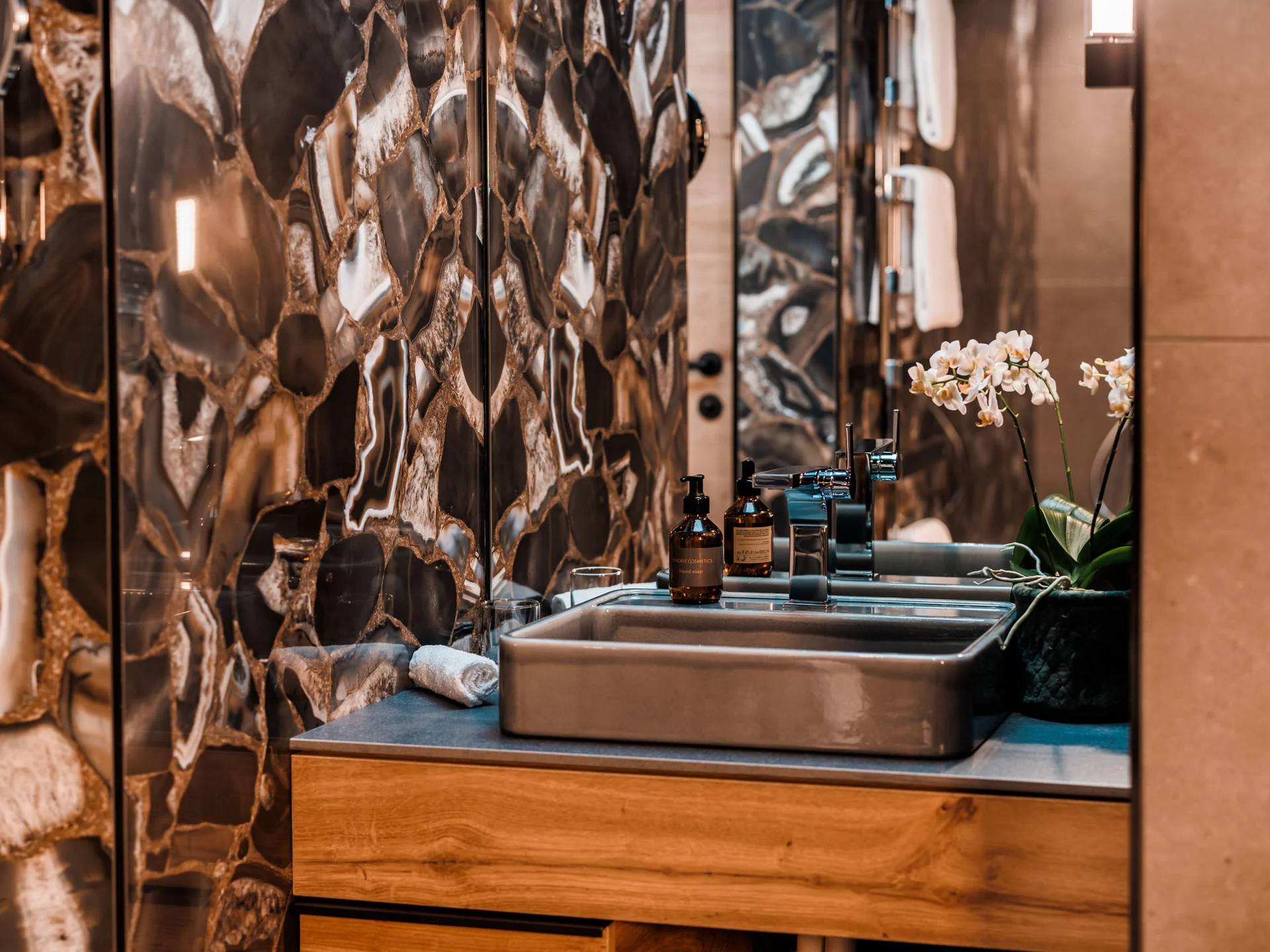 Bilder, die Sie sehen müssen. Moderner Badezimmerwaschbecken mit Marmorwand und Orchideenpflanze