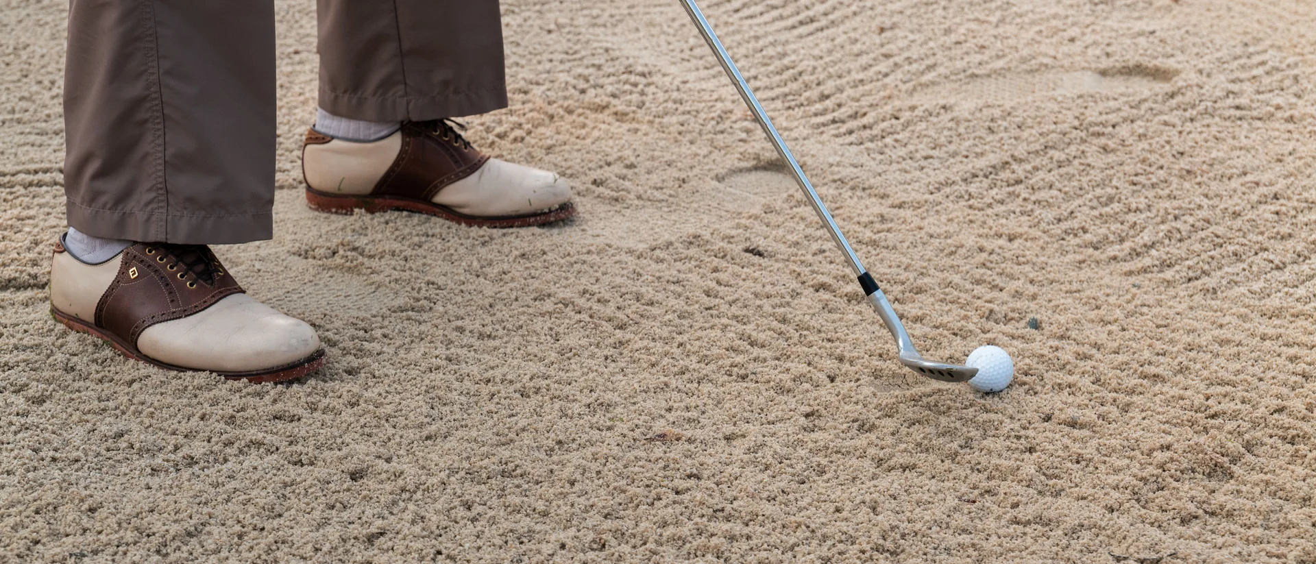 Das Golfhotel in Kitzbühel Golfschläger kurz vor dem Schlag auf einen Golfball im Bunker