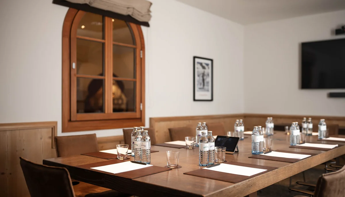 Ihr Firmenevent oder Meeting im Schlosshotel Kitzbühel Konferenzraum mit Tisch, Wasserflaschen, Gläsern, Notizblöcken und Stühlen