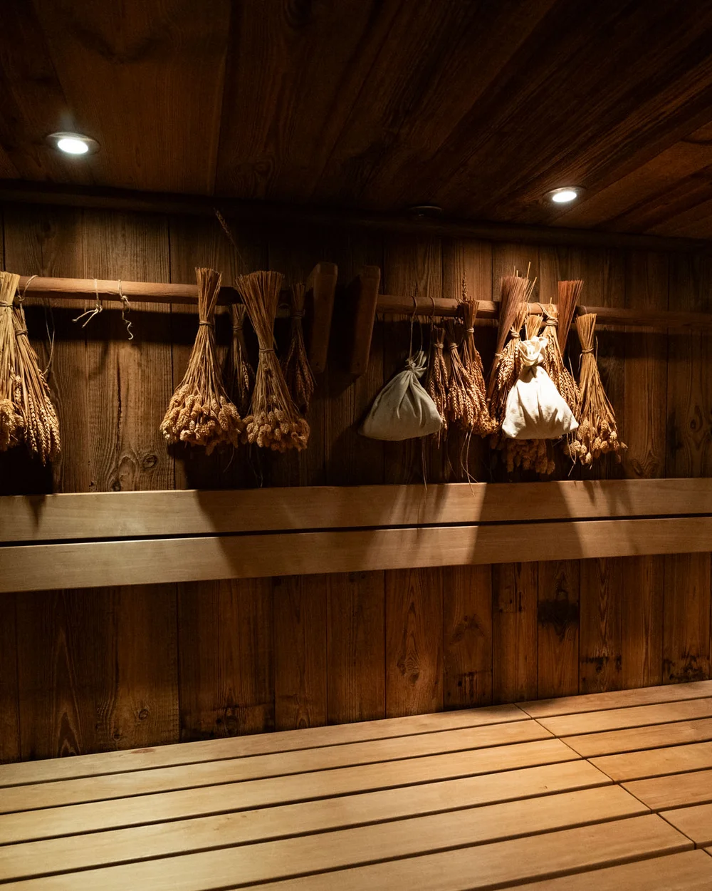 In Kitzbühel ein Hotel mit Pool, bitte. Holzsauna mit Bündeln aus getrockneten Kräutern und Lichtspots