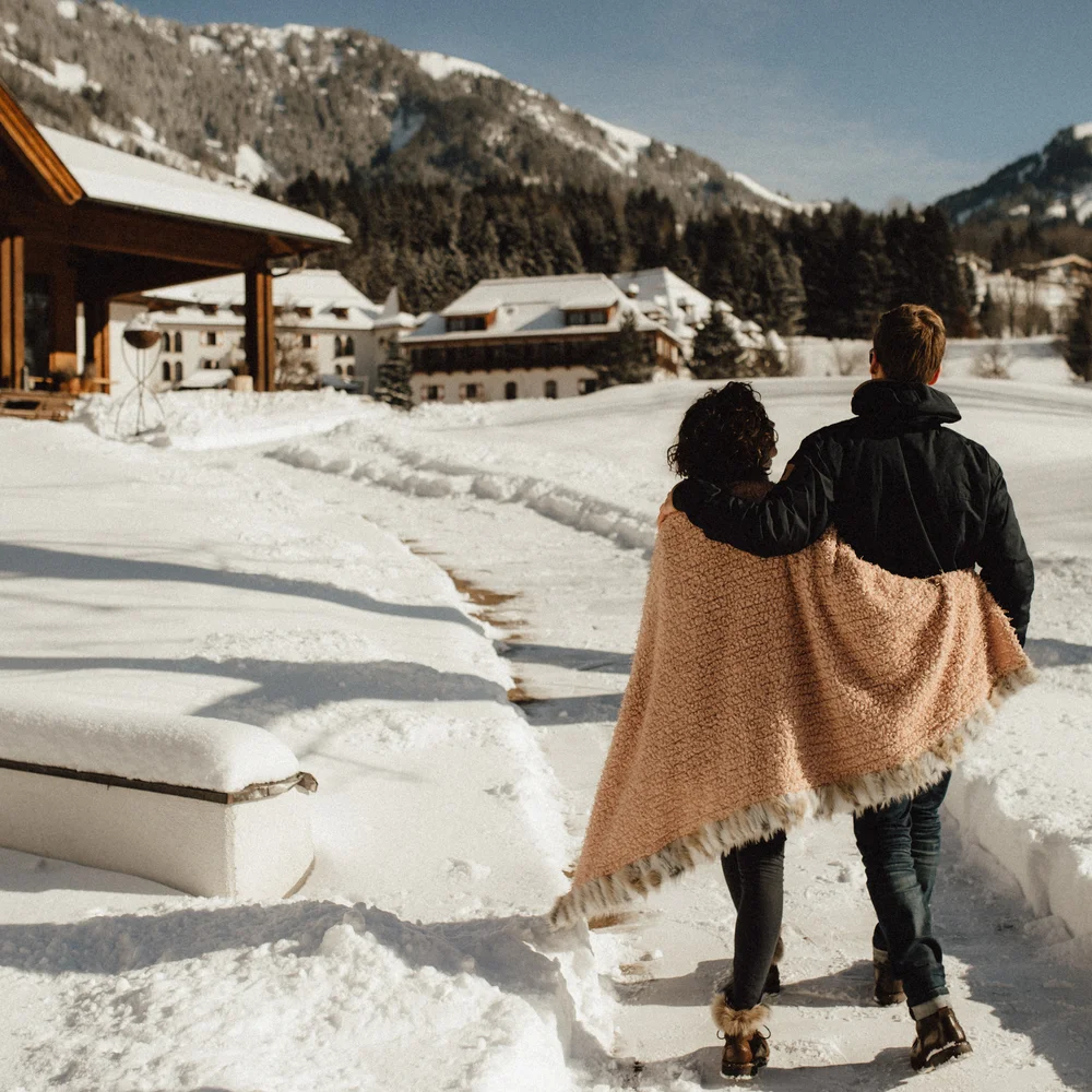 Ein ganzes Jahr in Bewegung Paar geht ausgestreckt durch schneebedeckten Weg in den Bergen