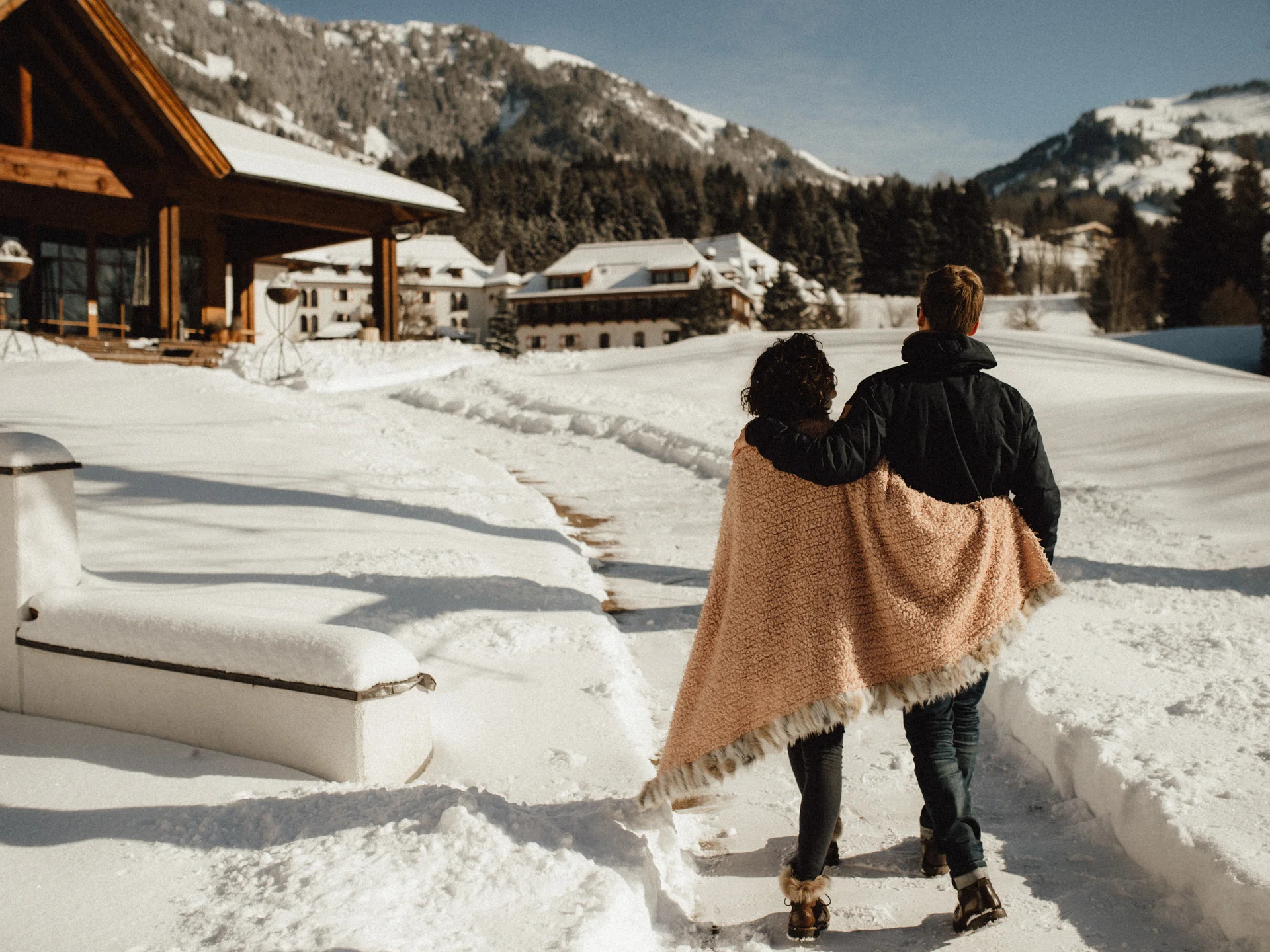 Bilder, die Sie sehen müssen. Paar geht ausgestreckt durch schneebedeckten Weg in den Bergen