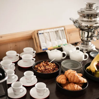 Exklusiv tagen im Seminarhotel in Tirol Kaffee- und Frühstückstisch mit Croissants, Obst, Milch und Kaffeezubehör