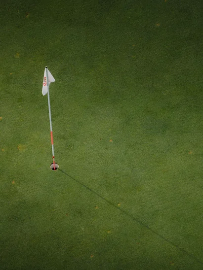 Das Golfhotel in Kitzbühel Golfloch mit Fahne auf grünem Golfplatz von oben