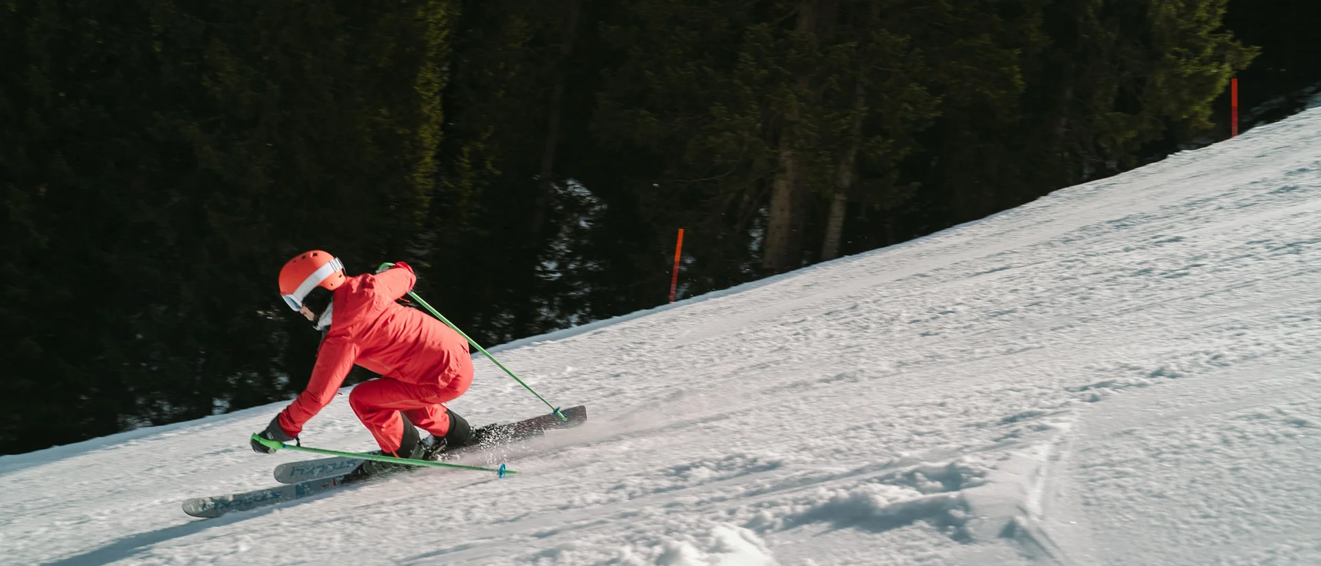 Ultimatives Skihotel in Kitzbühel Skifahrer in roter Ausrüstung fährt einen schneebedeckten Hang hinunter