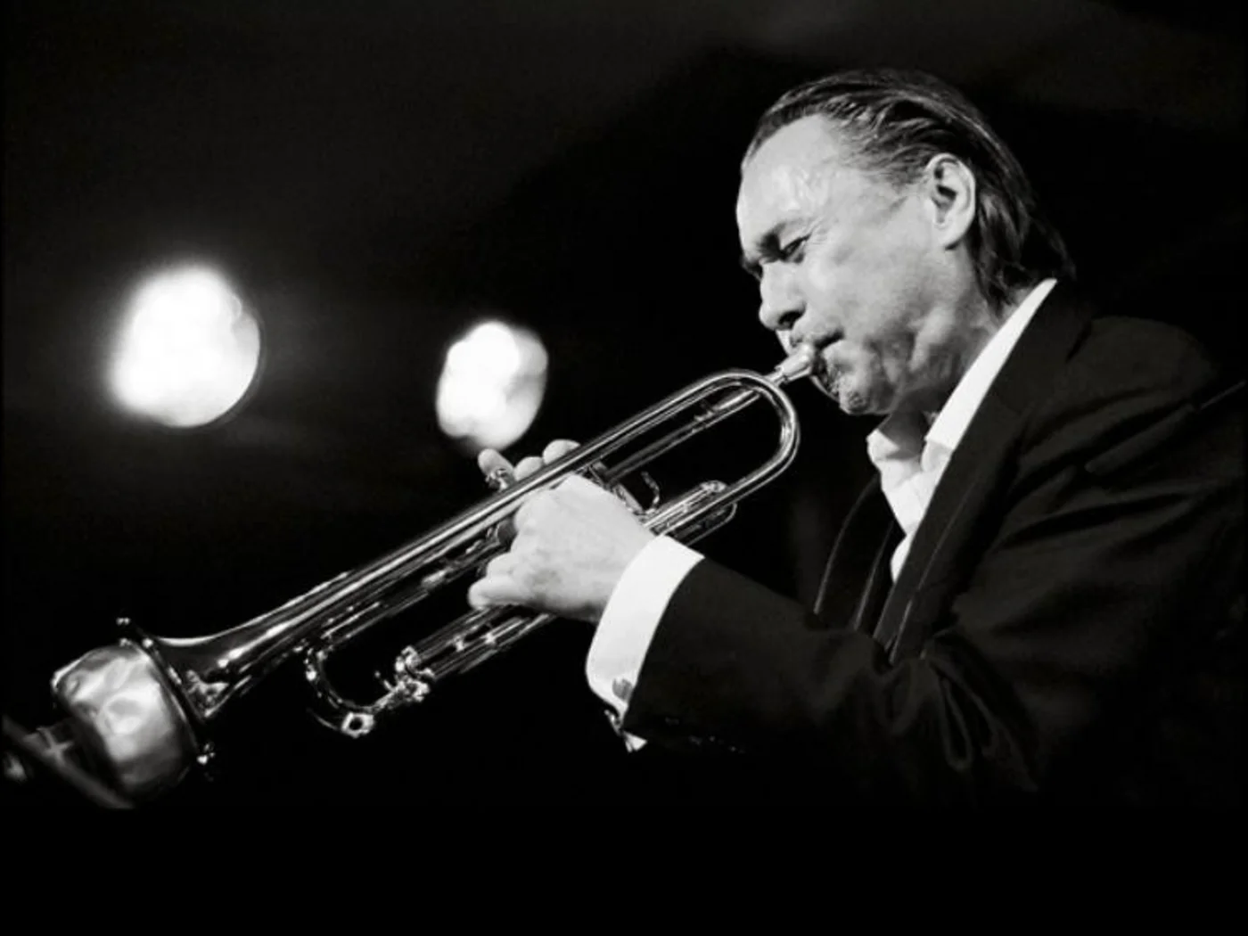 Die Schlossevents Schwarzweißbild eines Mannes im Anzug, der Trompete spielt