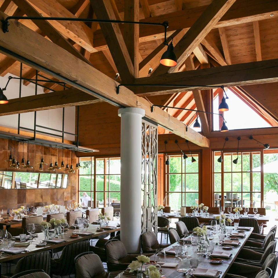 Eine der schönsten Hochzeitslocations in Tirol Innenansicht eines eleganten Restaurants mit Holzbalkendecke und festlich gedeckten Tischen