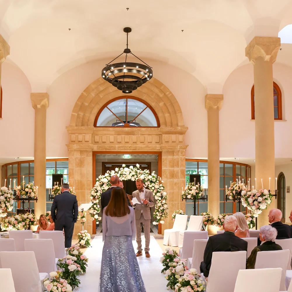 Eine der schönsten Hochzeitslocations in Tirol Festlich dekorierte Hochzeitszeremonie in einem eleganten Saal mit Gästen