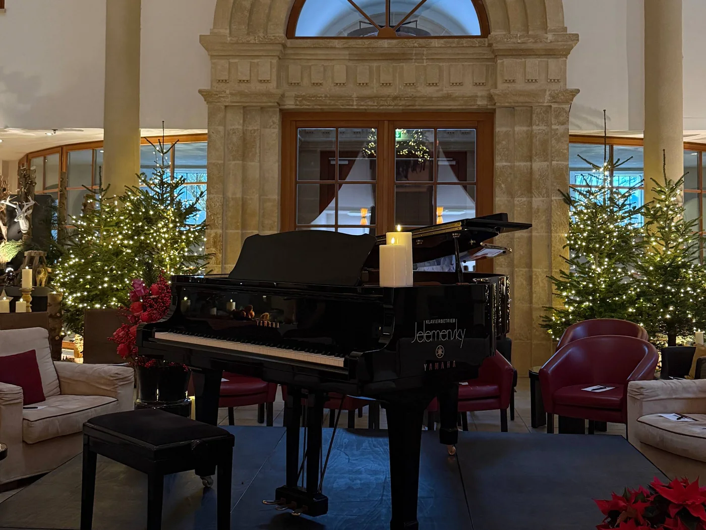 Die Schlossevents Weihnachtlich geschmückter Raum mit einem Flügel und einem hängenden Weihnachtsbaum