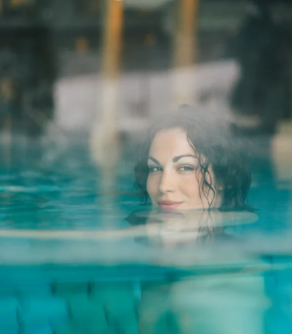 In Kitzbühel ein Hotel mit Pool, bitte. Frau entspannt sich in einem Dampfbad mit Wasser und Nebel