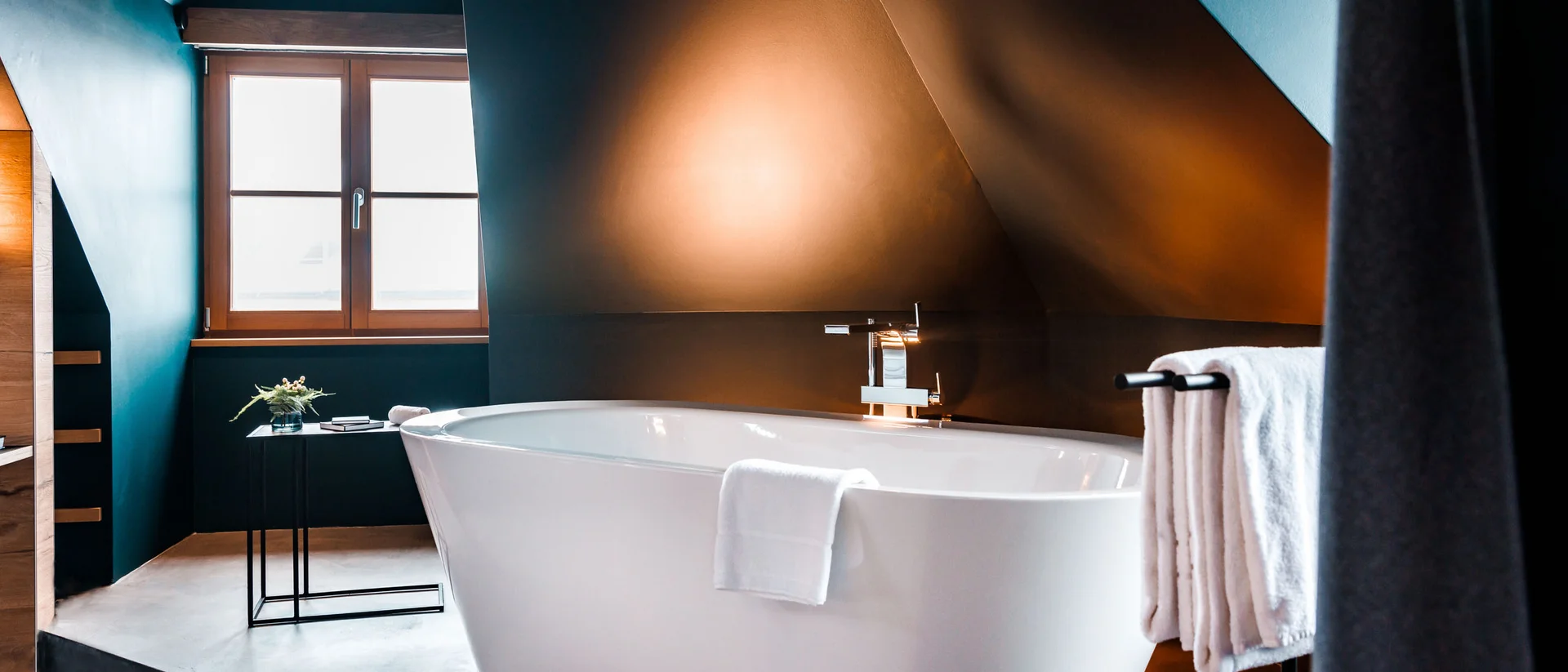 Ein Hotel mit freistehender Badewanne? Moderne freistehende Badewanne in stilvollem Badezimmer mit gedämpftem Licht