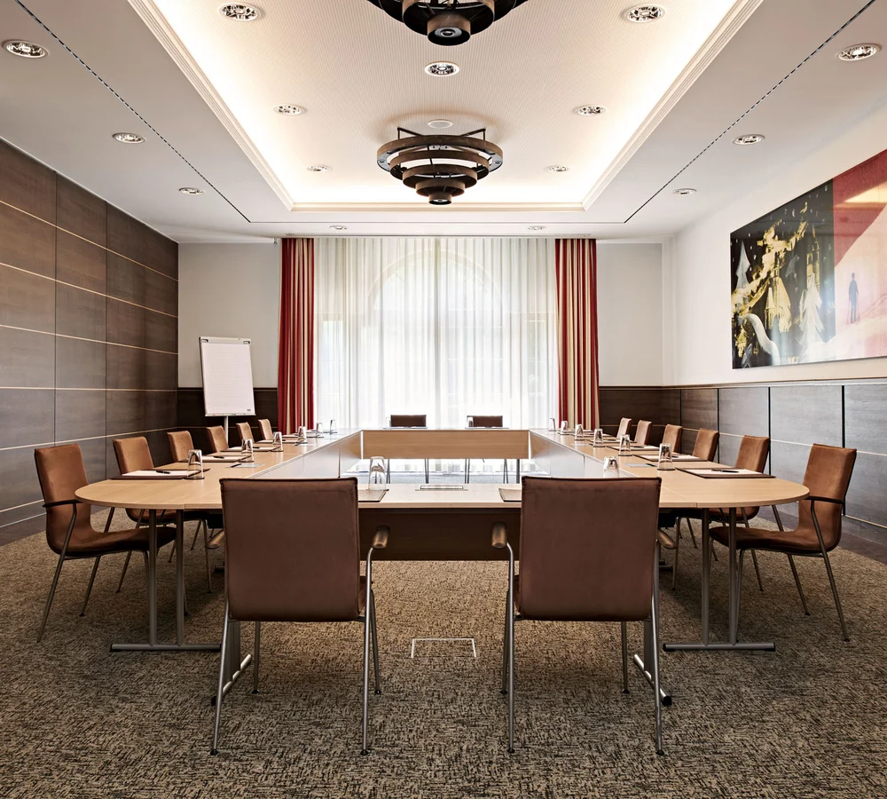 Ihr Firmenevent oder Meeting im Schlosshotel Kitzbühel Moderner Konferenzraum mit U-förmigem Tisch und braunen Stühlen