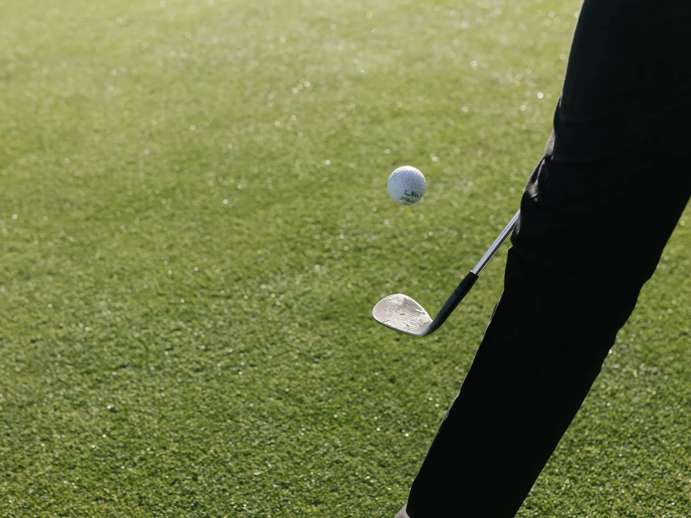 Die Schlossevents Person schlägt Golfball mit Golfschläger auf grünem Golfplatz
