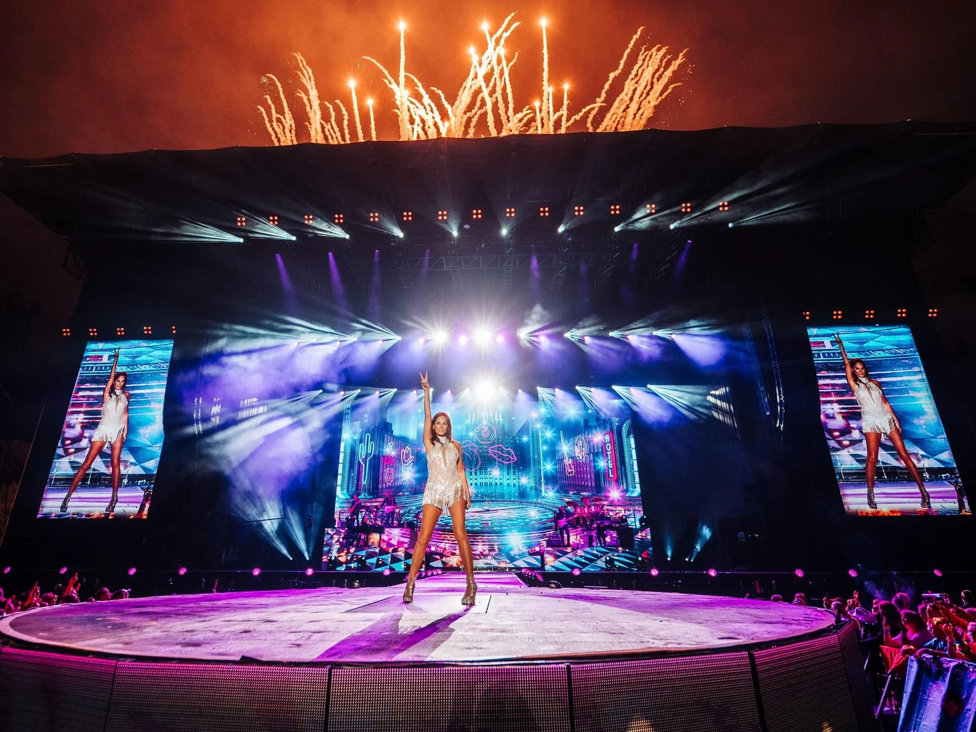 Die Schlossevents Sängerin auf runder Bühne mit Feuerwerk und bunten Lichtern bei Konzert