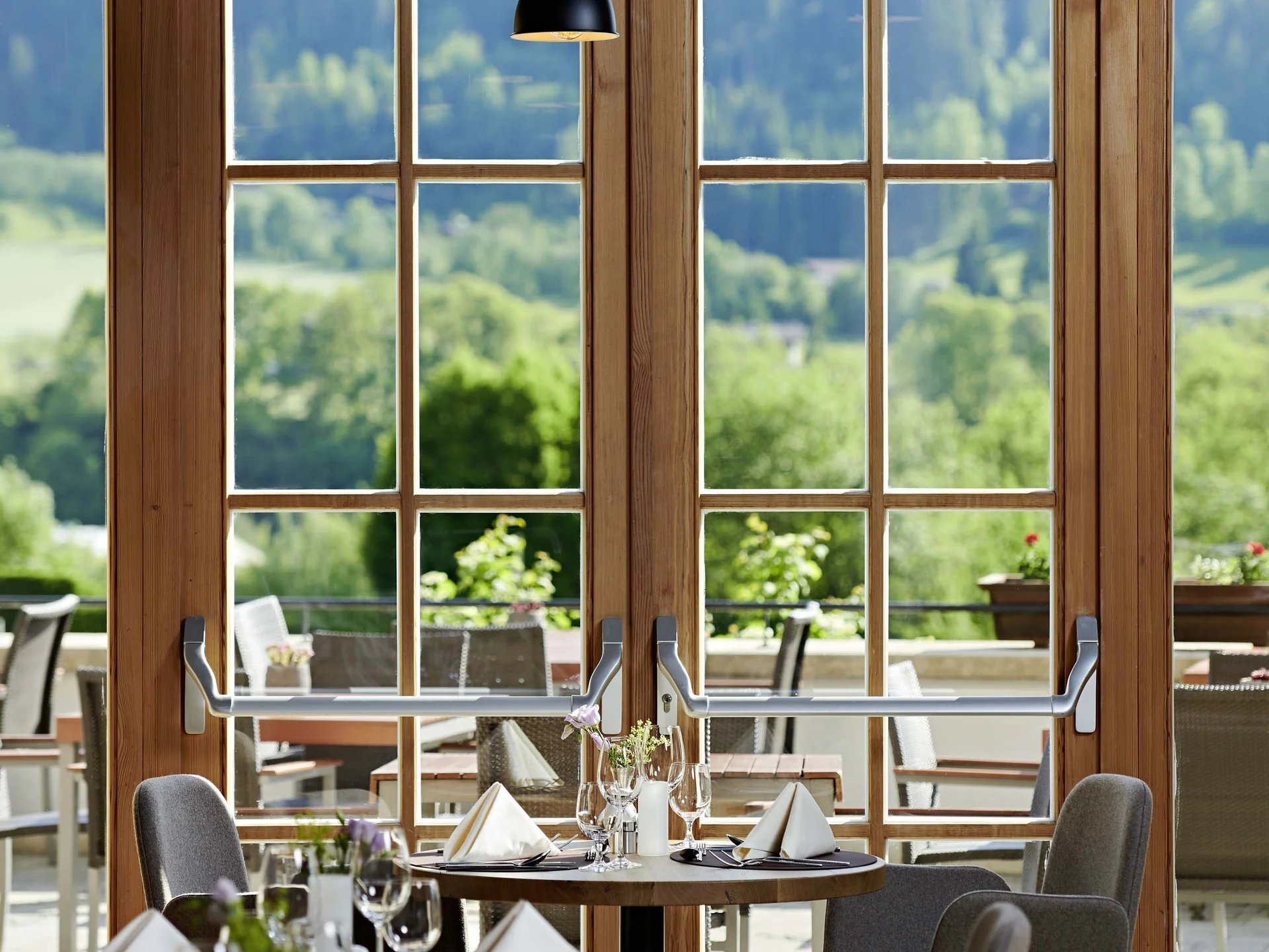 Bilder, die Sie sehen müssen. Elegantes Restaurant mit gedeckten Tischen und Blick auf eine grüne Landschaft