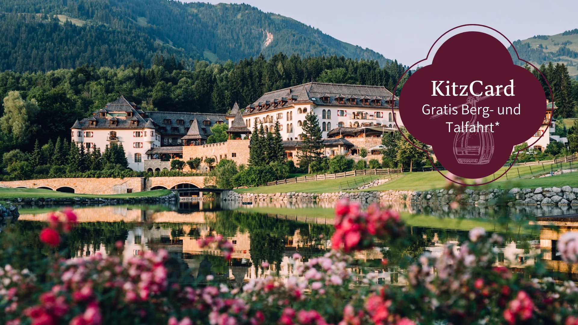 Schlosshotel Kitzbühel – ein Premiumerlebnis Schloss vor bewaldetem Berg mit See und Blumen im Vordergrund